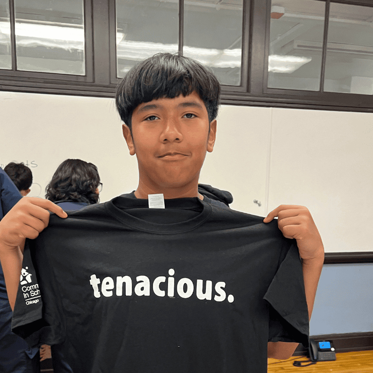 Tenacity Award winner from Saucedo E.S. holds up "tenacious" T-shirt